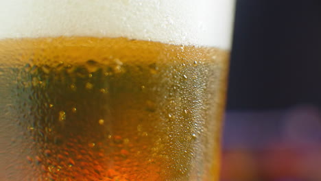 Bier-Nahaufnahme.-Pint-Kaltes-Craft-Bier-Isoliert-Auf-Mattschwarzem-Hintergrund,-Drehung-Um-360-Grad.-Glas-Bier-Mit-Wassertropfen.